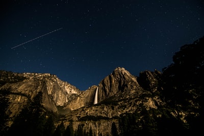 低角度摄影的岩石山在黑色的天空在夜间
